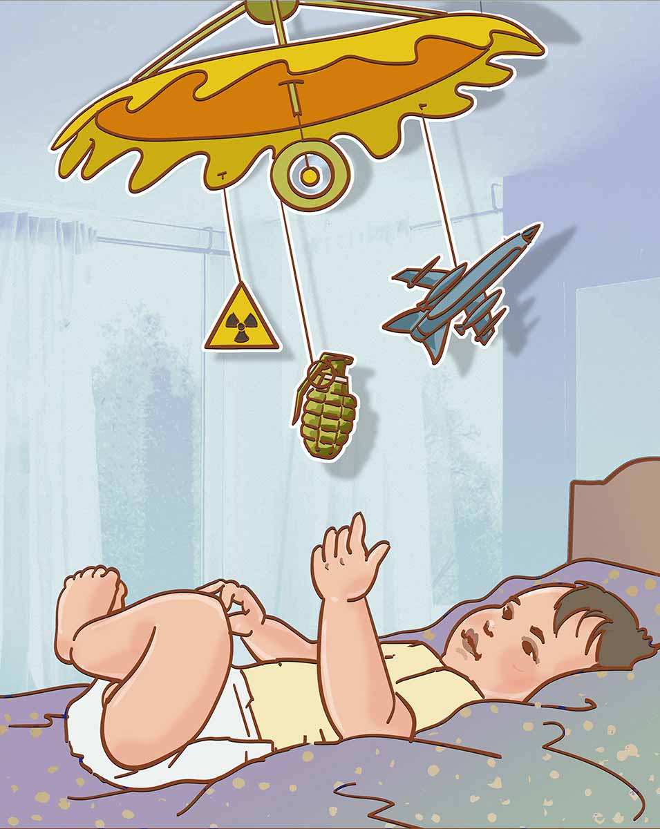 Ein Baby liegt in seinem Bettchen und spielt mit seinem Mobile, an dem verschiedene Waffen hängen