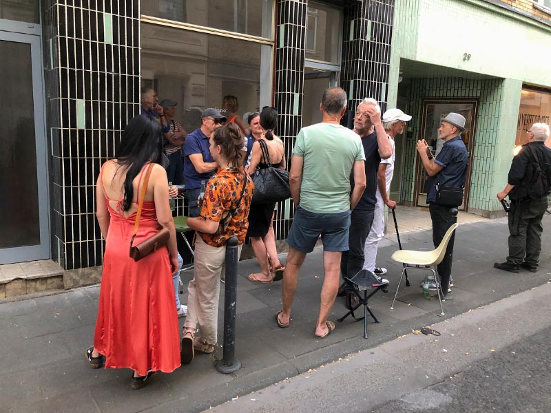 Besucher einer Ausstellung bei der Vernissage vor der Galerie